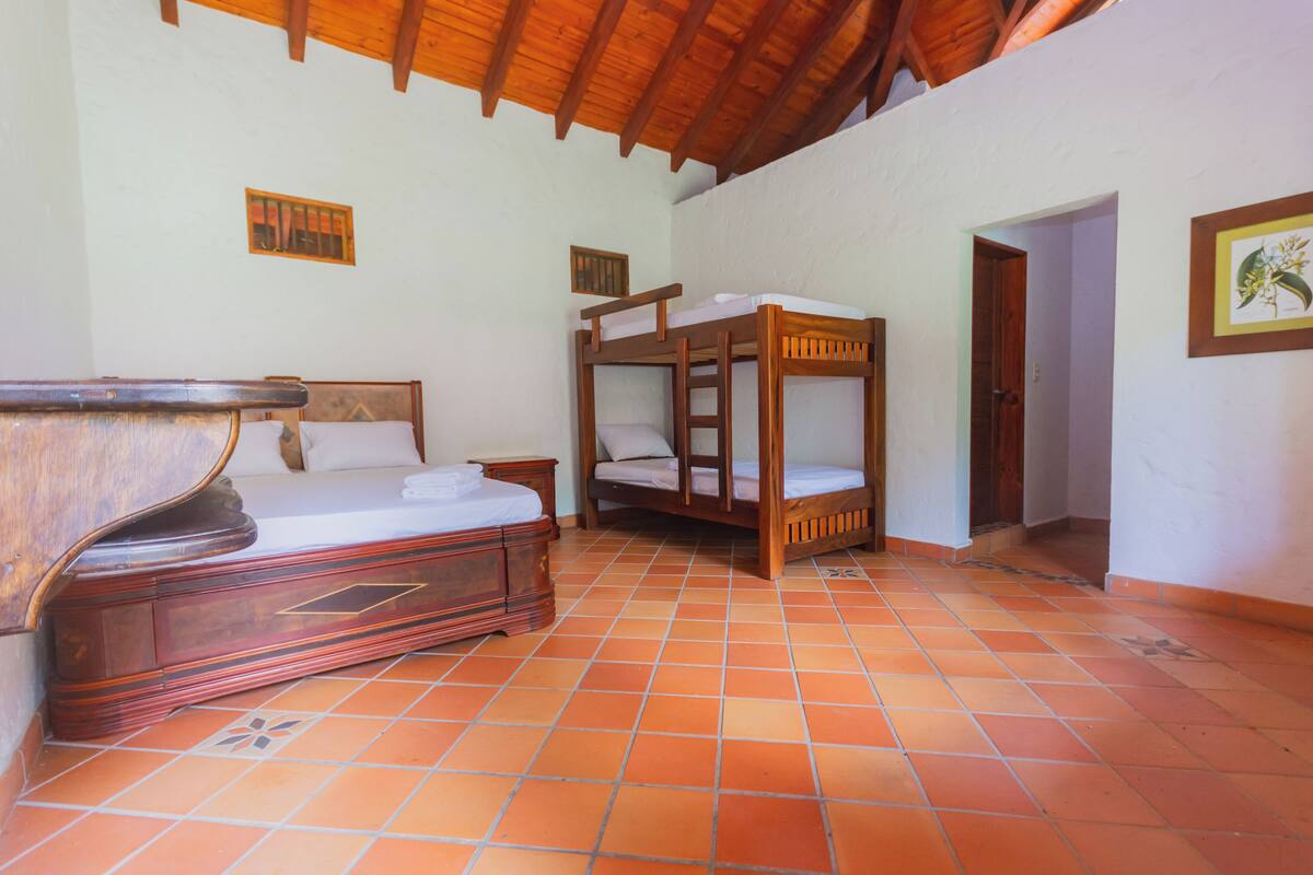 A room with a wooden bed, a wooden bunk bed, and a wooden cabinet.