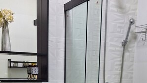 A modern bathroom with a glass-enclosed shower, a white sink, and a mirror above it. - Ap Próximo ao IME UFRJ e Pão de Açúcar (Rio de Janeiro)