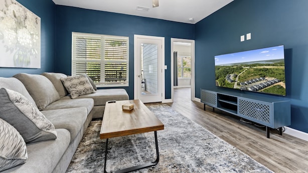 A living room with a sofa, coffee table, and TV. - Luxury Condo / Pool / Game Room / Grill / Pets (Branson)