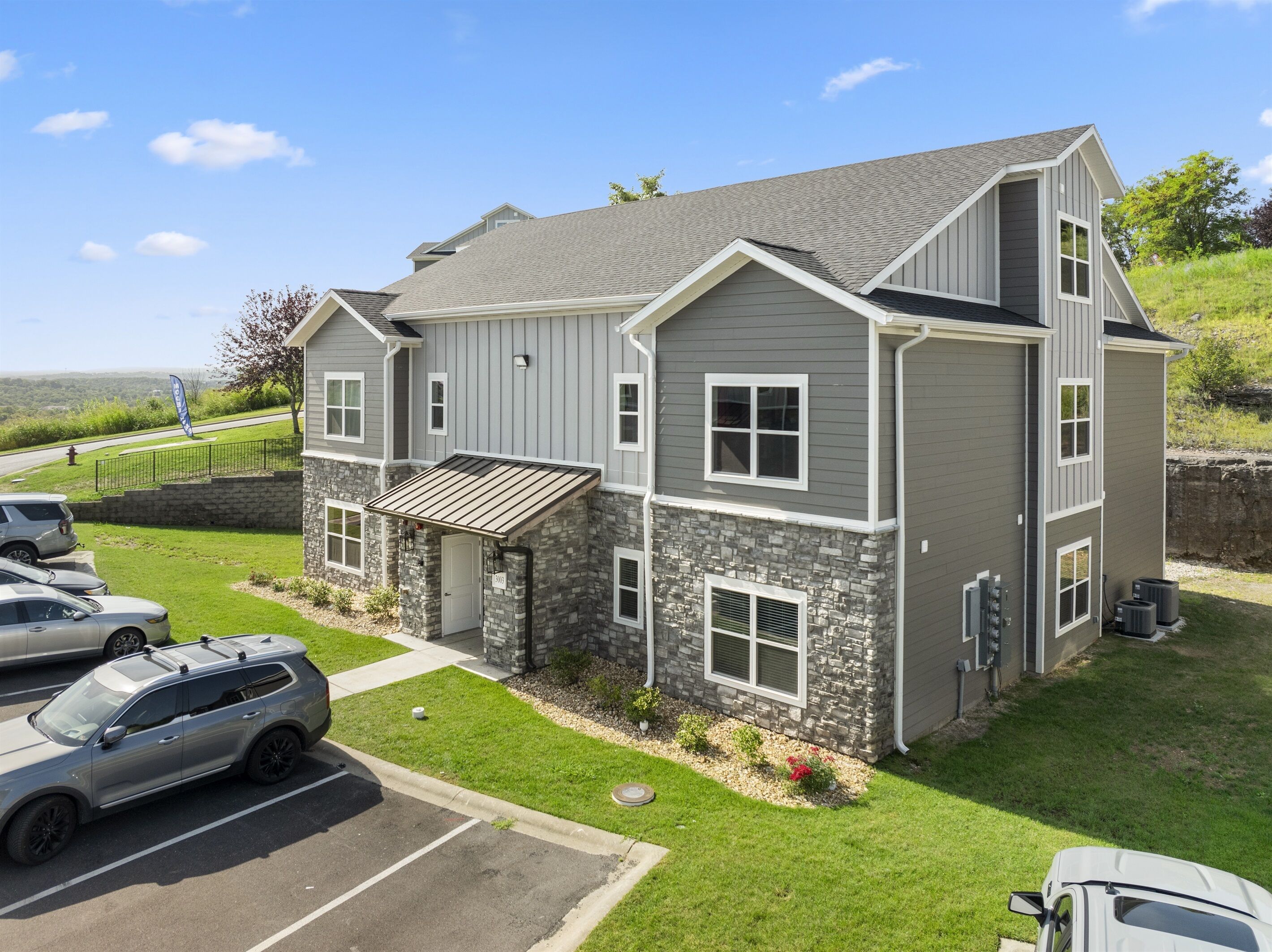 A two-story house with a stone facade and a sloped roof.