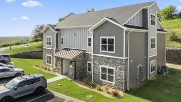 A two-story house with a stone facade and a sloped roof.