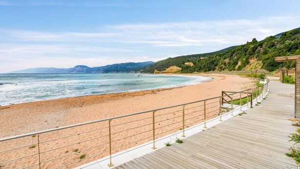 A beach with a wooden boardwalk and a metal railing. - Amazing home in Orgosolo (Orgosolo)