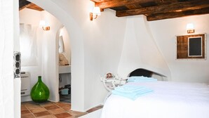 A bedroom with a bed, white walls, a wooden ceiling, and a green bottle on the floor. - Amazing home in Orgosolo (Orgosolo)