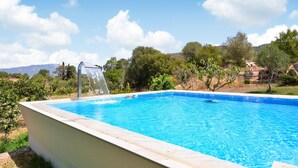 A rectangular swimming pool with a clear blue water surface, surrounded by a low white wall. - Amazing home in Orgosolo (Orgosolo)