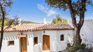 A white building with a tiled roof, two wooden doors, and a small window. - Amazing home in Orgosolo (Orgosolo)