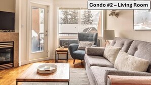 Un salon comprenant un canapé, un fauteuil, une table basse et une cheminée.