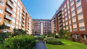 A multi-story residential building with balconies, a central courtyard, and surrounding greenery. - Modern Lofts in Puerto Madero (Buenos Aires)