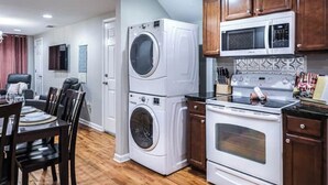 Une cuisine compacte équipée d’un appareil combinant lave-linge et sèche-linge, d’un four à micro-ondes et d’un four traditionnel.