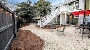 Un patio couvert avec des sièges d’extérieur, un escalier et une pergola.