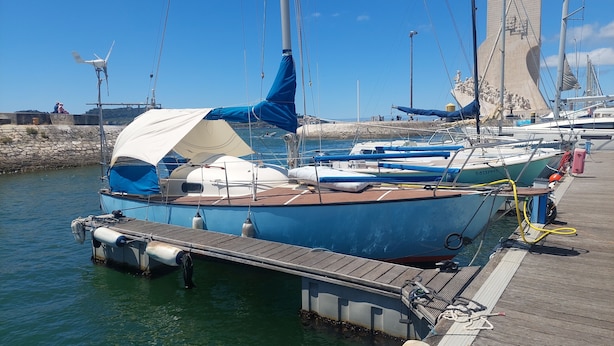 A marina with several sailboats docked at wooden piers.
