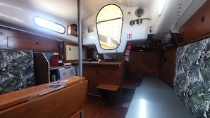A compact cabin with a small desk, a chair, a bed, and a window.