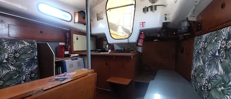 A compact cabin with a small desk, a chair, a bed, and a window.