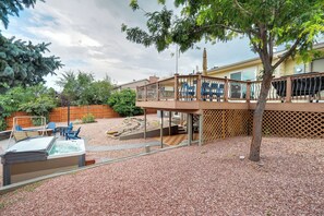 A backyard with a hot tub, patio furniture, and a wooden deck. - Colorado's Best (Colorado Springs)