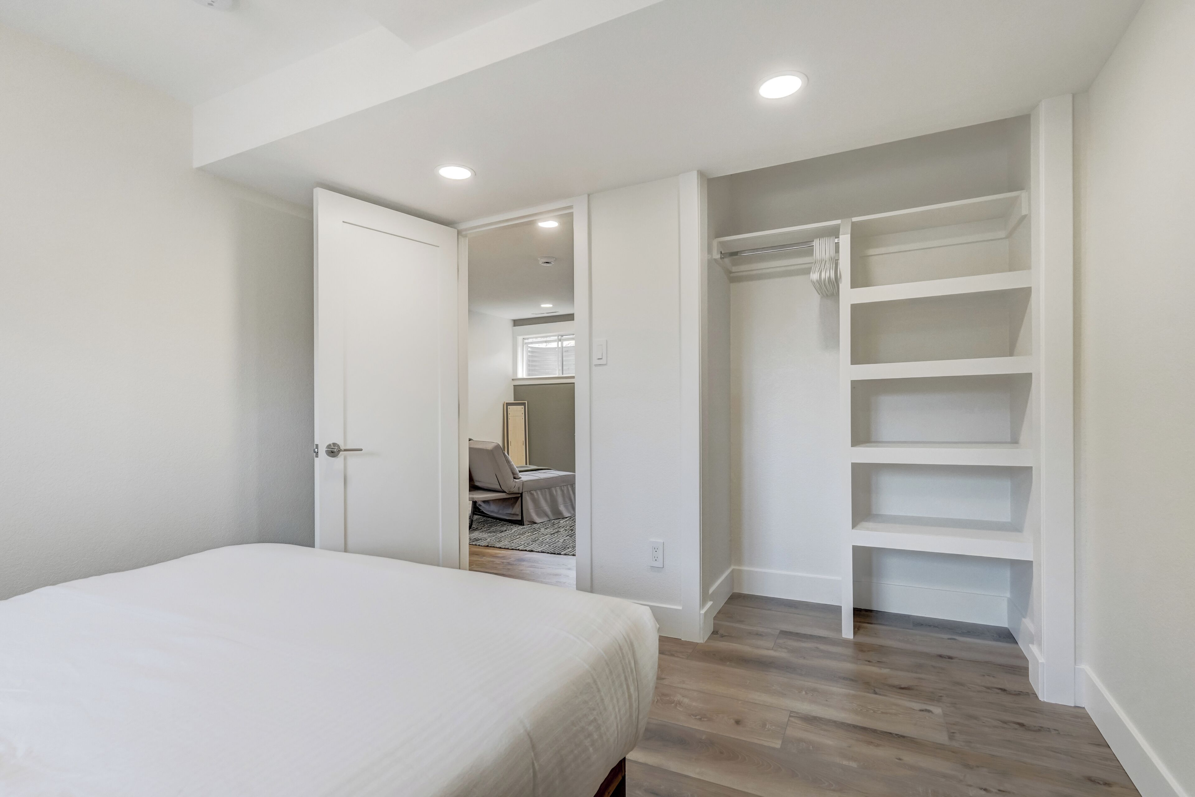 Une chambre à coucher avec un lit, un dressing et une vue sur une autre pièce.