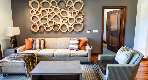 Una sala de estar con un sofá modular, una mesa de centro y un tapete estampado.