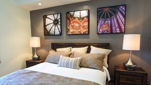A bedroom with a large bed, two bedside tables with lamps, and three wall-mounted artworks depicting Ferris wheels. - Mountain View w/ Fireplace | Ski Valet & Shuttle (South Lake Tahoe)
