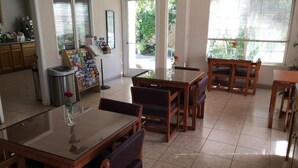 A dining area with wooden tables and chairs, a trash bin, and a menu stand. - Formosa Inn (Fresno)