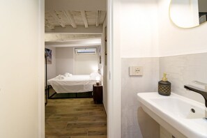 A bedroom with a bed, a bedside table, and a nightstand.