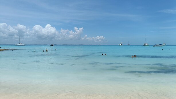 A beach with clear turquoise water, several boats, and a sandy shore. - Cómodo, céntrico a cuadra y media de playa norte (Isla Mujeres)