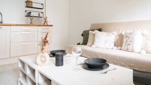 A modern kitchen with white cabinets, a wooden countertop, and a built-in stove. - Appartement Lavoisier - Welkeys (Puteaux)