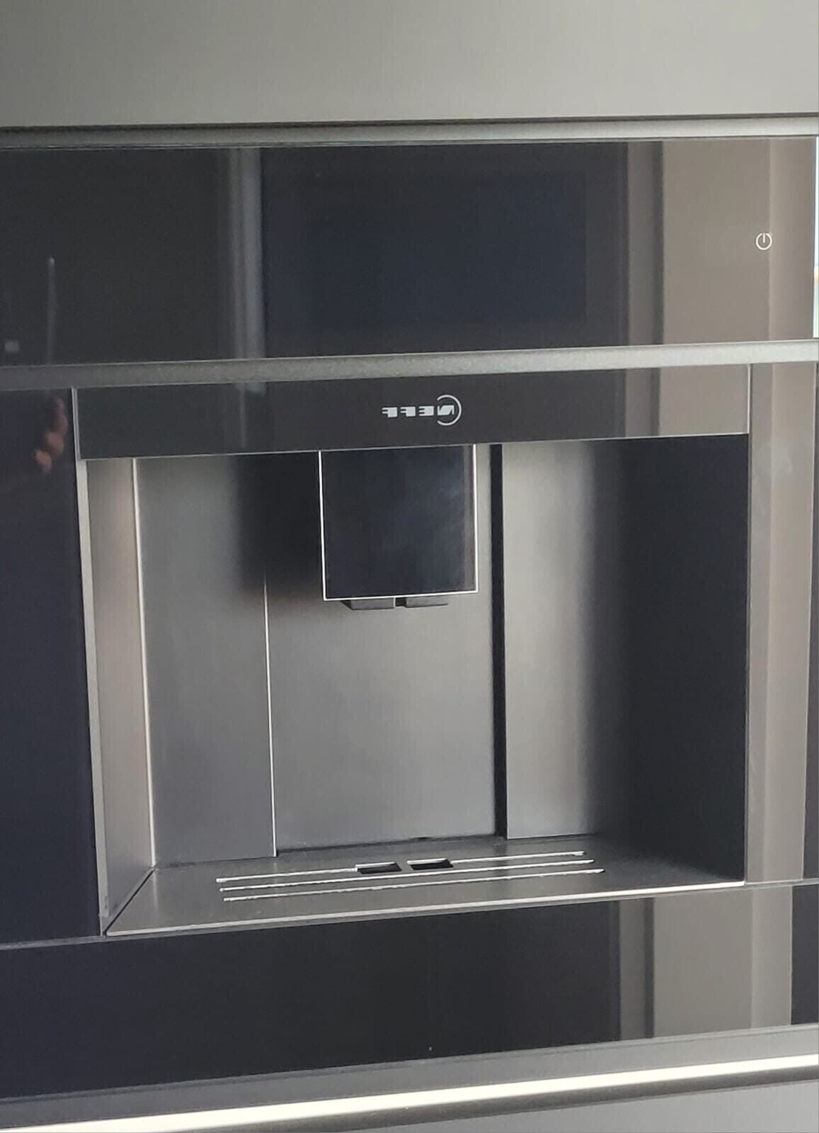 Une cuisine moderne en acier inoxydable, dotée d’une machine à café intégrée.