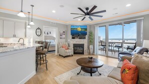 A spacious living area with a fireplace, a dining area, and a kitchen with a large island.