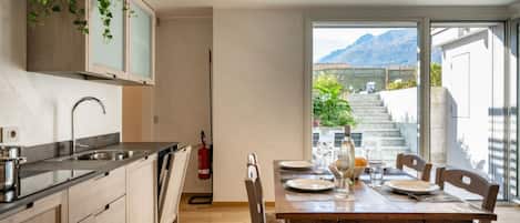 A modern kitchen with wooden cabinets and a dining area with a wooden table and chairs.
