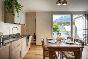 Een moderne keuken met houten kastjes en een eethoek met een houten tafel en stoelen.
