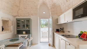 Een keuken met witte kastjes, een Bosch magnetron en uitzicht op het buiten.