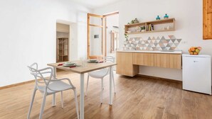 Une cuisine moderne avec un plan de travail en bois, des armoires blanches et un petit réfrigérateur.