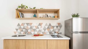 A kitchen with a white countertop, wooden cabinets, a stainless steel refrigerator, and a geometric backsplash. - Apartment 'Travel Rooms-Arenella Piano Terra 1' with Mountain View, Wi-Fi and Air Conditioning (Palermo)