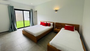 A hotel room with two beds, a sliding glass door to a balcony, and a wall-mounted light fixture. - Vacation Home 'Villa Maria' with Mountain View, Wi-Fi and Air Conditioning (Playa Blanca)