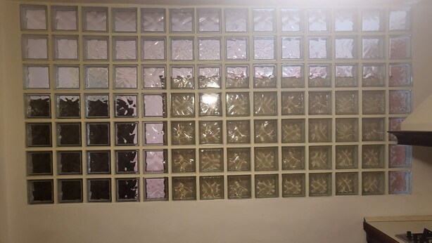 A wall with a grid of square windows, some with visible damage.