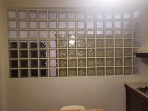 A wall with a grid of square windows, some with visible damage.