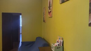 A room with a bed, a dresser, and a wall with artwork.
