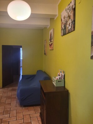 Een kamer met een bed, een dressoir en een wand met kunstwerken.