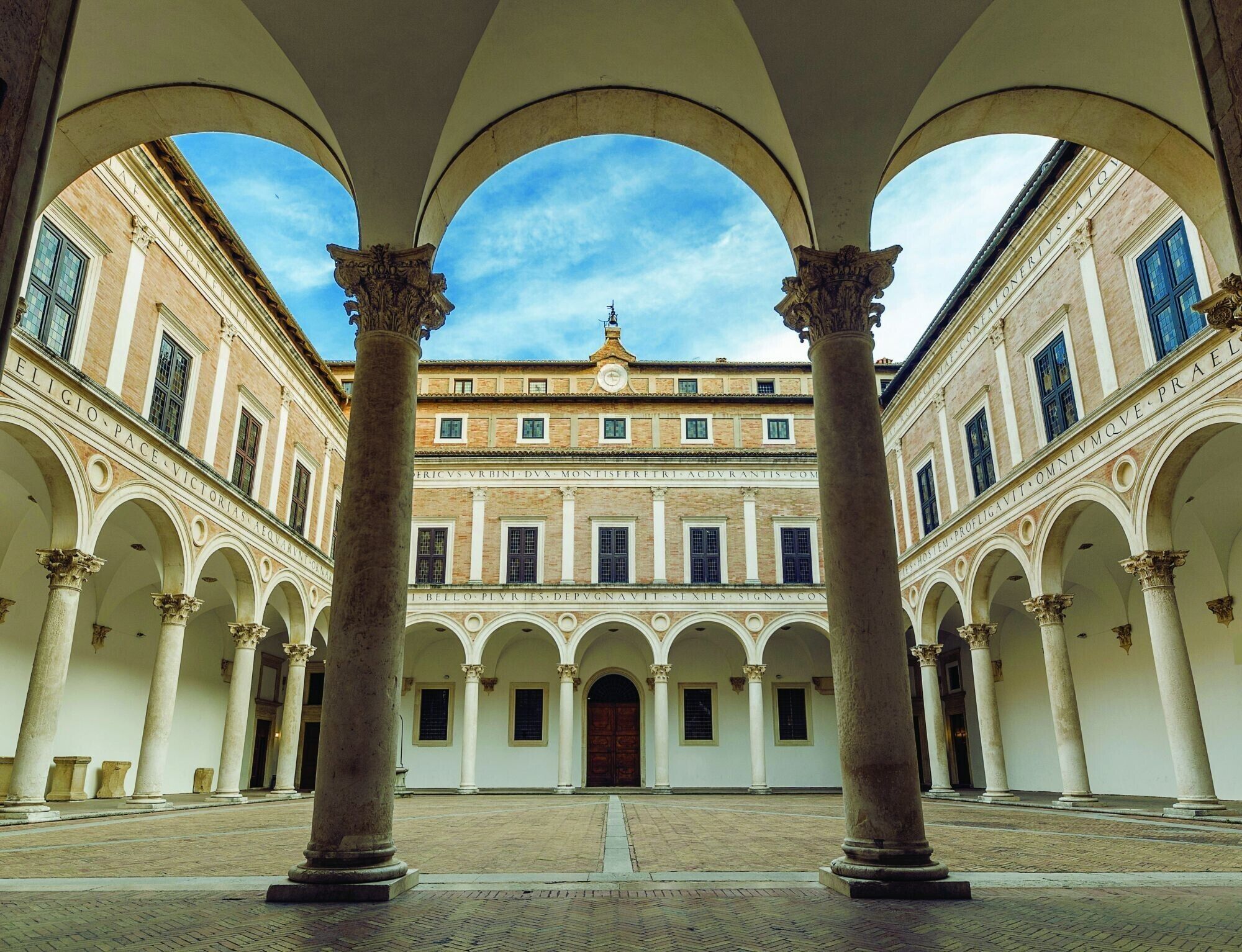 Un patio con arquitectura clásica, con columnas y arcos.