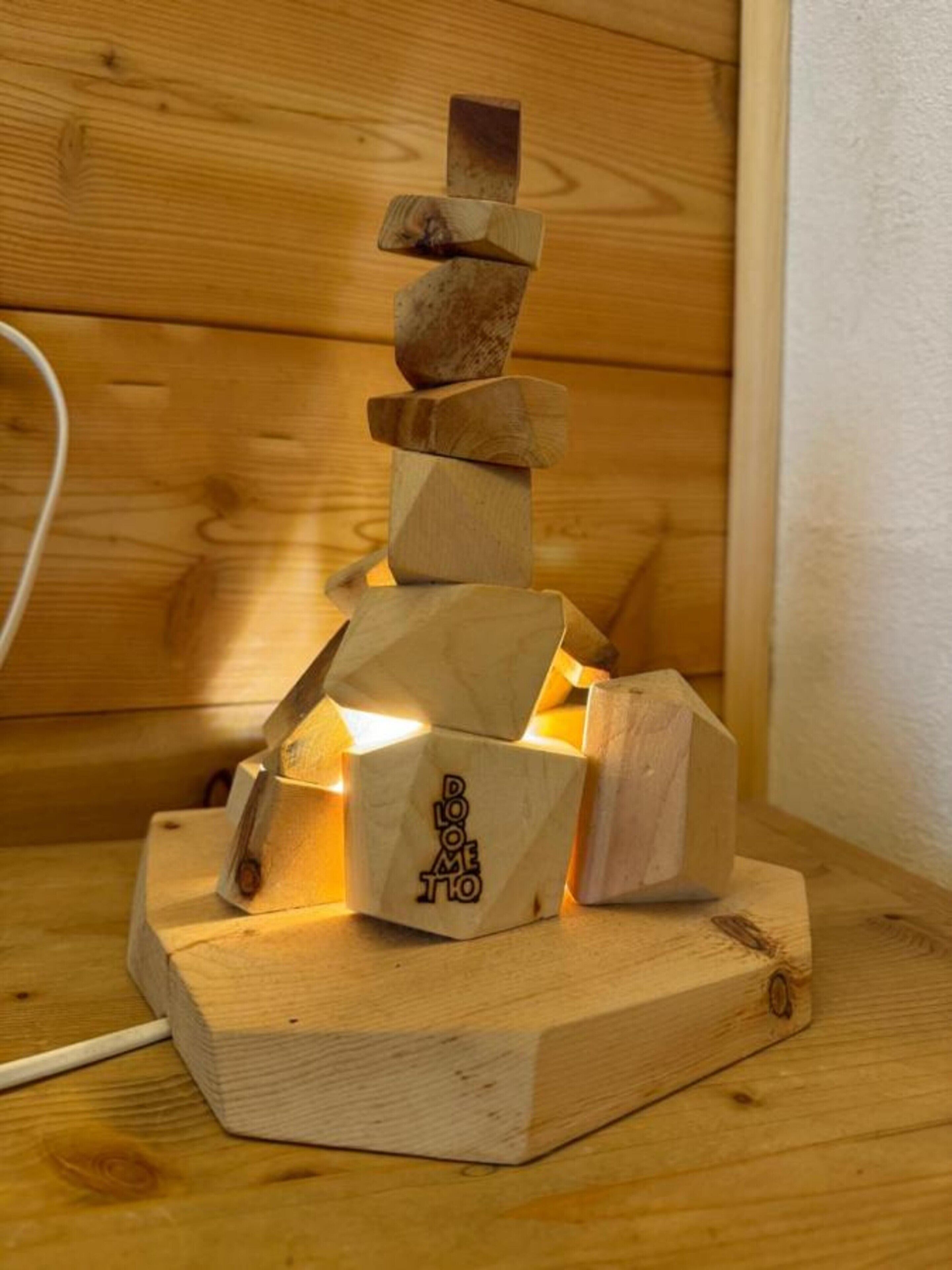 A wooden sculpture with geometric shapes stacked on a wooden base.