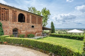 A rustic brick building with a covered patio, a soccer goal, and a view of the countryside. - Apartment 'Lo Stornello' with Shared Pool, Wi-Fi and Air Conditioning (Fucecchio)