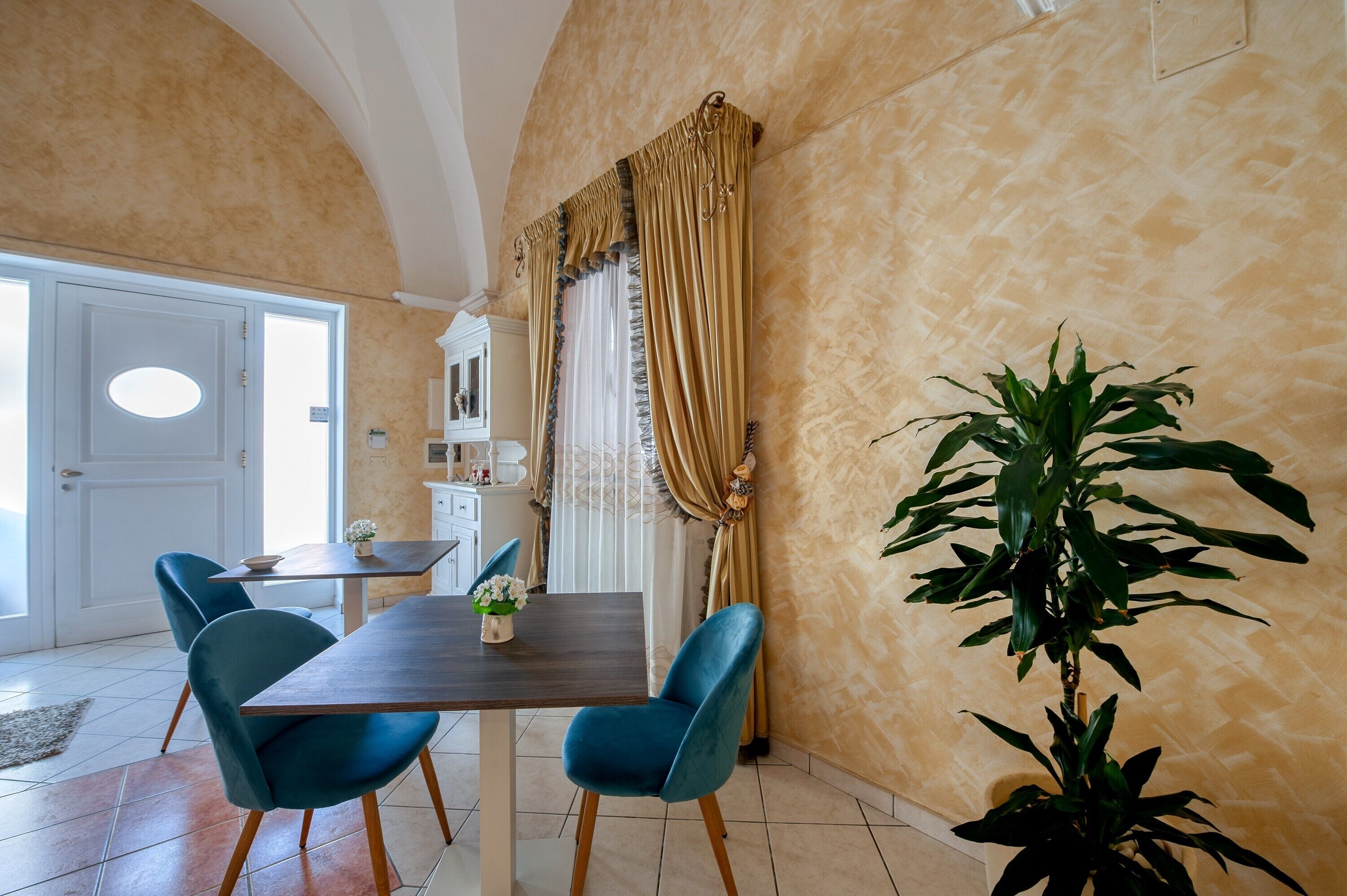 A dining area with a table, chairs, and curtains.