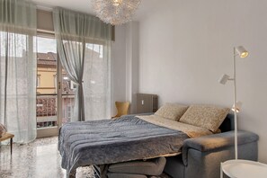 Une chambre à coucher avec un lit, un radiateur, une lampe sur pied et une vue par la fenêtre.