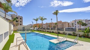 Ein Pool mit Stufen, umgeben von Gebäuden und Palmen.
