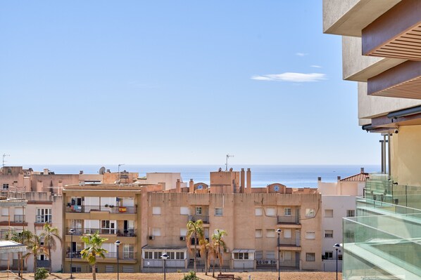 Uma área residencial costeira com edifícios altos, varandas e vista clara para o mar.