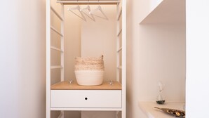 A closet with shelves, a hanging rack, and a wooden shelf with a woven basket. - Room 'Relais Luxury Xenia - Ulivo' with Shared Pool, Wi-Fi and Air Conditioning (Sternatia)