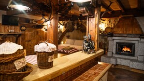 Un interior rústico con chimenea, vigas de madera y pared de piedra.