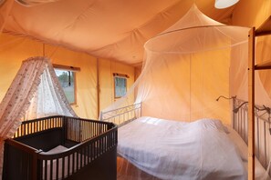 Una habitación con tienda de campaña, una cama y un mosquitero.