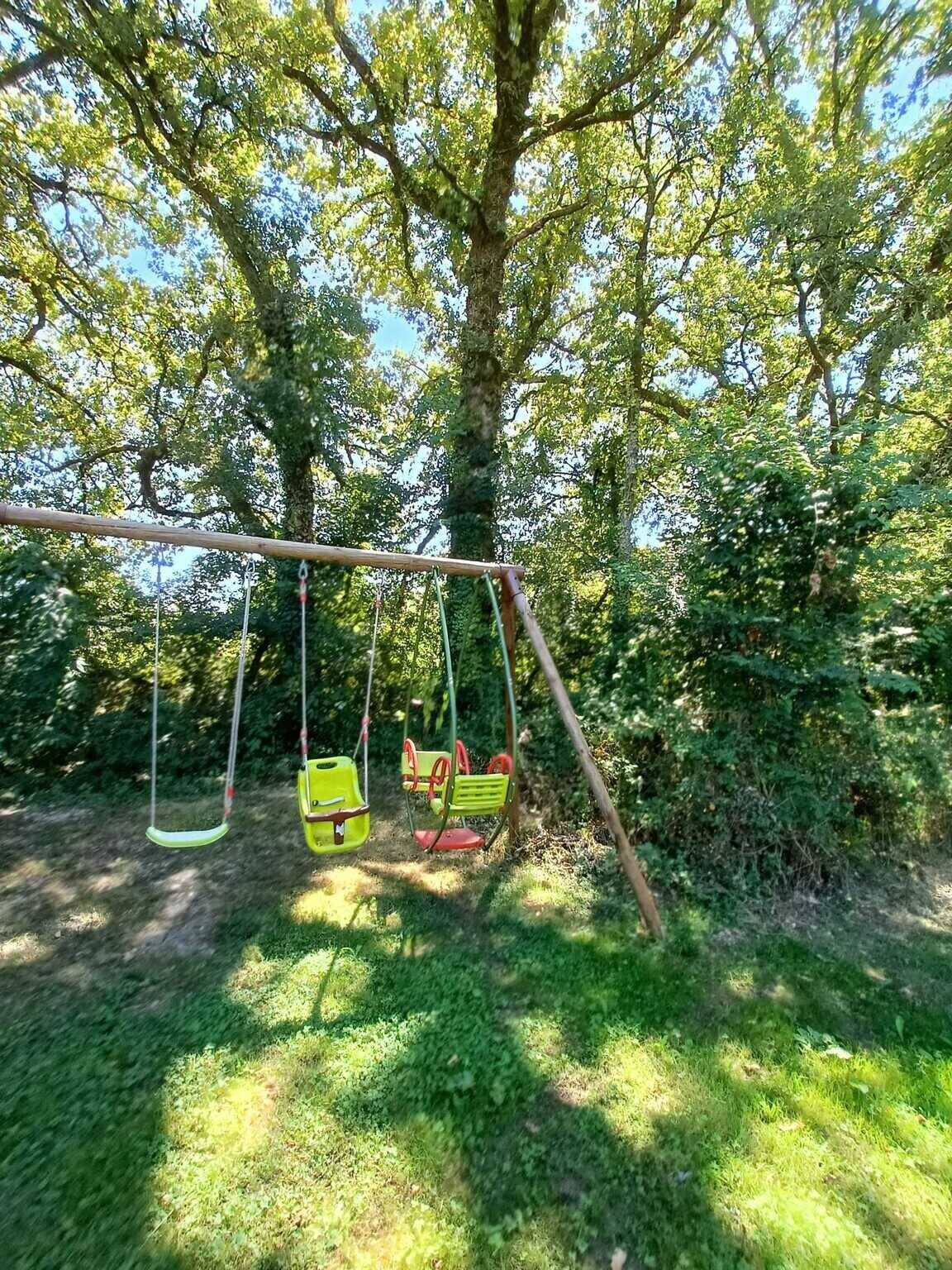 A swing set in a wooded area.