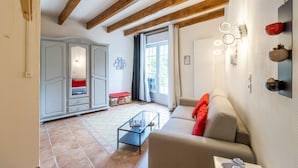 Un salon avec un canapé, une table basse en verre et un plafond en bois.