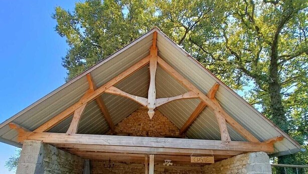 Un bâtiment en pierre avec un toit en bois et une enseigne sur laquelle on peut lire « Cuisinier ».