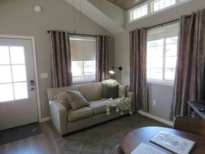 A living room with a sofa, a lamp, and a dining table.